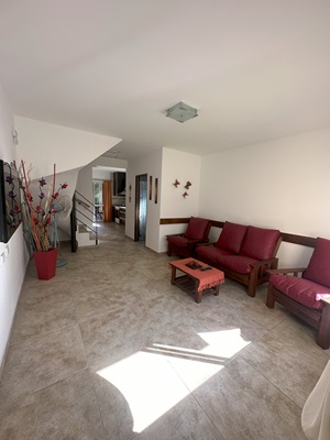 Amplio living comedor con sofá, mesa y TV, muy luminoso y cómodo